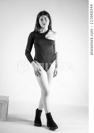 Beautiful young sexy girl in a black bodysuit on a white background 111668344