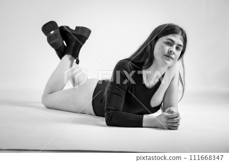 Beautiful young sexy girl in a black bodysuit on a white background Beautiful young sexy girl in a black bodysuit on a white background 111668347