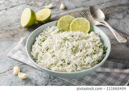 Delicious rice with garlic, cilantro, lime and zest close-up in a bowl. Horizontal 111668404