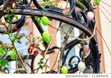 Colorful painted decorative Easter eggs hanging by an iron frame outside Colorful painted decorative Easter eggs hanging by an iron frame outside 111668426