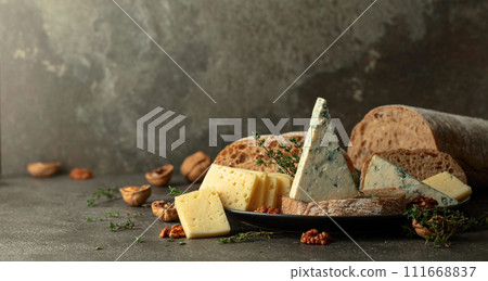 Cheese, bread, walnuts, and thyme on a stone kitchen table. 111668837