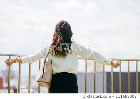 Rear view of a business woman taking a deep breath and stretching (refreshing, stretching, enriching) Rear view of a business woman taking a deep breath and stretching (refreshing, stretching, enriching) 111669302