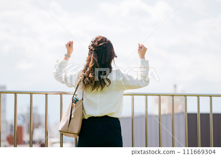 Rear view of a business woman who is motivated on the rooftop (inspired, working hard, courage, inspired, motivated) Rear view of a business woman who is motivated on the rooftop (inspired, working hard, courage, inspired, motivated) 111669304