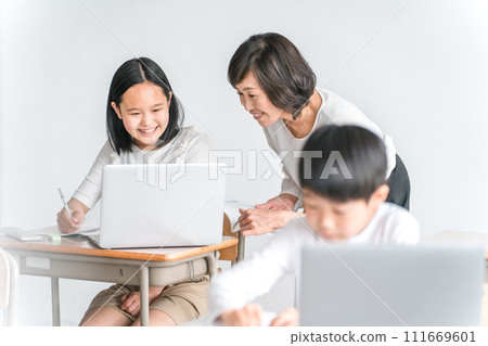 Elementary school girls and female instructors studying while using laptops in school classrooms (education, teacher, class, tutor) Elementary school girls and female instructors studying while using laptops in school classrooms (education, teacher, class, tutor) 111669601