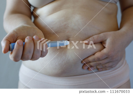 Woman with Semaglutide Injection Pen against her Stomach. Semaglutide Injection Diabetes Drug Woman with Semaglutide Injection Pen against her Stomach. Semaglutide Injection Diabetes Drug 111670033