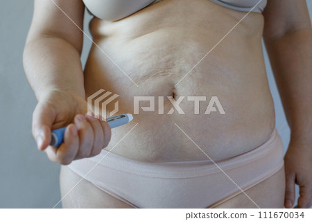 Semaglutide Injection. Semaglutide or insulin Injection pen and female body closeup  111670034