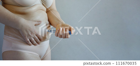 Patient Female model making Semaglutide Injection Pen in her Stomach.  111670035