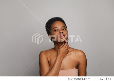 Good-looking healthy young woman with dark shiny skin smiling looking at camera on white background. 111670154