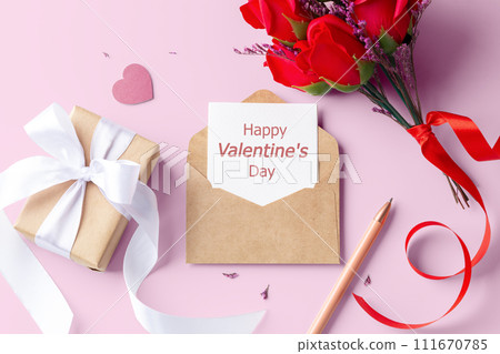 Valentine card in kraft envelope with gift box and rose on pink background, top view Valentine card in kraft envelope with gift box and rose on pink background, top view 111670785