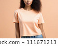 Woman in peach fuzz colored tshirt, can be used for design, mock up. The trending color of 2024. 111671213