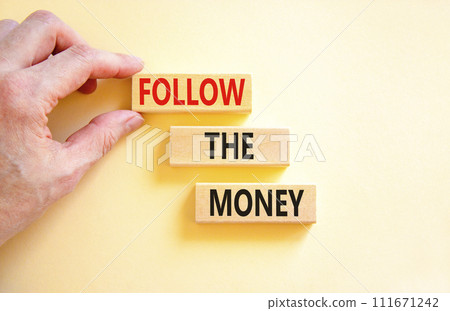 Follow the money symbol. Concept words Follow the money on beautiful wooden blocks. Beautiful white table white background. Businessman hand. Business and follow the money concept. Copy space. Follow the money symbol. Concept words Follow the money on beautiful wooden blocks. Beautiful white table white background. Businessman hand. Business and follow the money concept. Copy space. 111671242