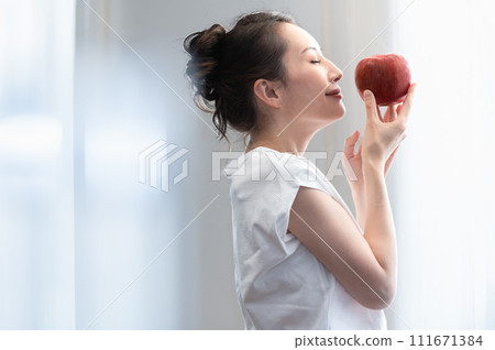 Beauty image of a woman holding an apple in her hand 111671384