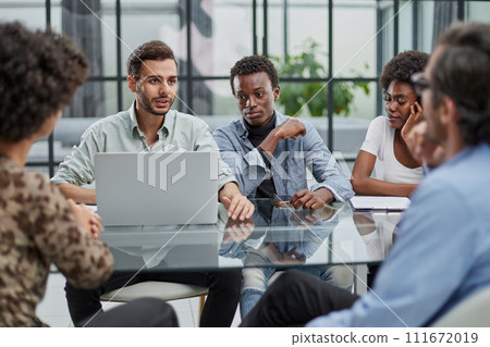 Employees working at computer together, discussing content Employees working at computer together, discussing content 111672019