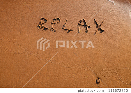 Hand drawn word Relax on wet yellow sand on beach of sea Hand drawn word Relax on wet yellow sand on beach of sea 111672850