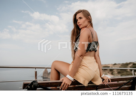 Woman travel sea. Happy tourist enjoy taking picture outdoors for memories. Woman traveler looks at the edge of the cliff on the sea bay of mountains, sharing travel adventure journey Woman travel sea. Happy tourist enjoy taking picture outdoors for memories. Woman traveler looks at the edge of the cliff on the sea bay of mountains, sharing travel adventure journey 111673135