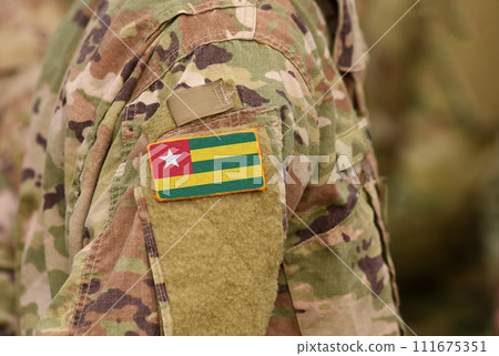 Togo flag on soldiers arm. Togolese Republic troops (collage) Togo flag on soldiers arm. Togolese Republic troops (collage) 111675351