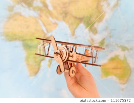 Travel and tourism concept. hand holding toy airplane against map of world 111675572