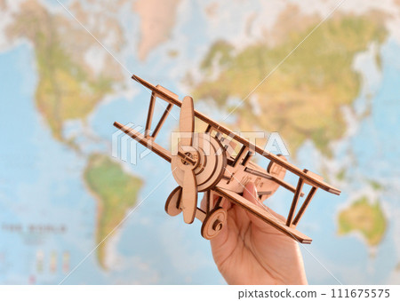 Travel and tourism concept. hand holding toy airplane against map of world 111675575