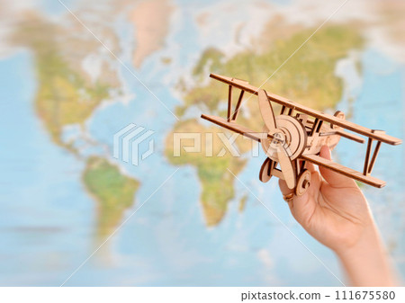 Travel and tourism concept. hand holding toy airplane against map of world Travel and tourism concept. hand holding toy airplane against map of world 111675580