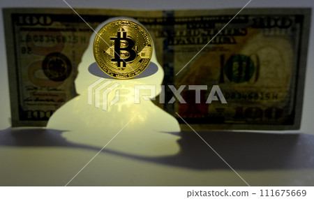 Bitcoin concept. New world currency. Gold coin of Bitcoin and silhouette of Benjamin Franklin on the one hundred dollars USA. Money concept. 111675669