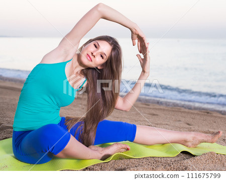 Woman in blue T-shirt is practicing stretching 111675799