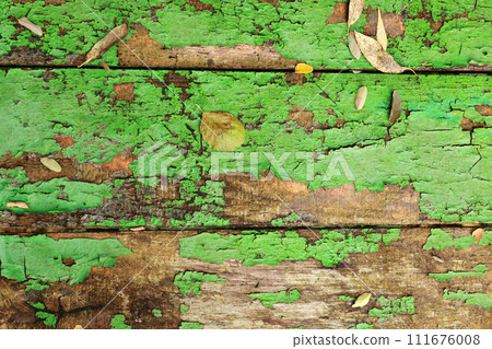 Old wooden background texture of boards with cracked green paint. table. Autumn yellow brown fallen leaves on shabby grunge wood panels, frame, flat lay. Old wooden background texture of boards with cracked green paint. table. Autumn yellow brown fallen leaves on shabby grunge wood panels, frame, flat lay. 111676008
