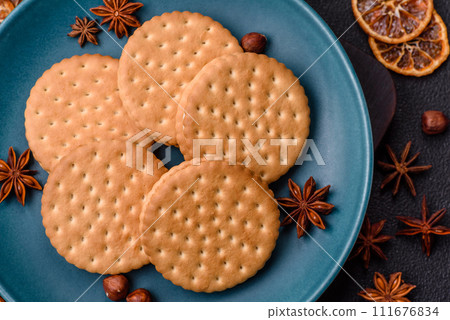 Round dotted snack snack cookies with cream on a dark concrete background 111676834