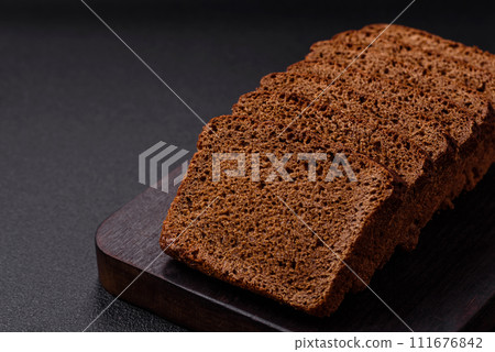 Delicious brown bread with seeds and grains cut into slices 111676842