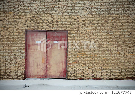 brick and metal double doors old rusty diry building facade background 111677745