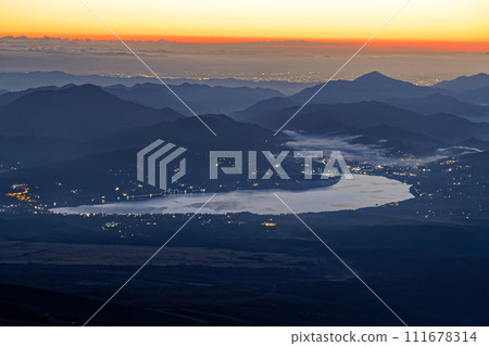 Lake Yamanaka and the city lights of the Kanto Plain at dawn seen from Mt. Fuji and Mt. Hoei Lake Yamanaka and the city lights of the Kanto Plain at dawn seen from Mt. Fuji and Mt. Hoei 111678314