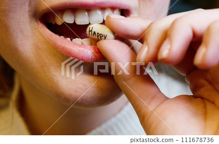 oval white tablet with the inscription happy in the mouth of a teenager oval white tablet with the inscription happy in the mouth of a teenager 111678736