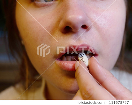 oval white tablet with the inscription happy in the mouth of a teenager oval white tablet with the inscription happy in the mouth of a teenager 111678737