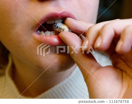 oval white tablet with the inscription happy in the mouth of a teenager oval white tablet with the inscription happy in the mouth of a teenager 111678758