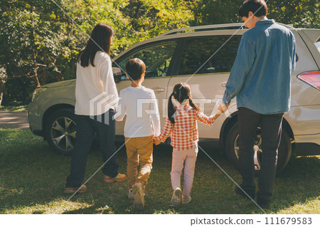 A family gets into a car returning from playing in the park. A family gets into a car returning from playing in the park. 111679583