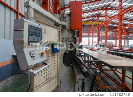 A machine is being used in a factory to manufacture products. 111682766