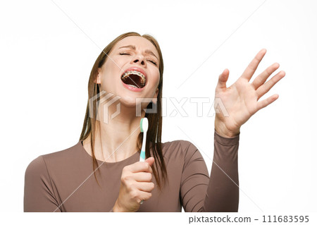 Young beautiful woman singing to toothbrush isolated on white background 111683595