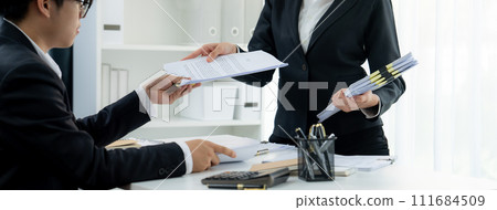 Corporate accountant team use calculator to calculate financial report. Shrewd Corporate accountant team use calculator to calculate financial report. Shrewd 111684509