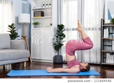 Flexible and dexterity woman in sportswear doing reverse gaiety yoga position 111684548