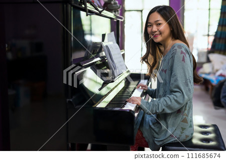 Portrait of Young Asian smiling pianist at home 111685674