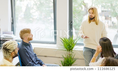 Young man talking during a business meeting in a coworking 111686125