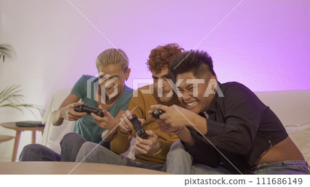 Happy and excited friends playing console at home 111686149