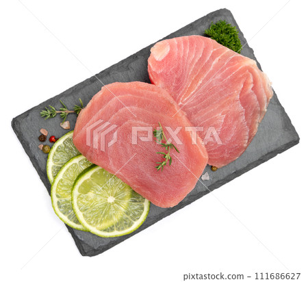 Fresh tuna Fish steak on stone serving board isolated on white background Fresh tuna Fish steak on stone serving board isolated on white background 111686627
