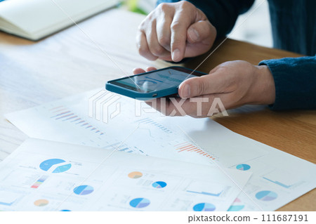 Hand of a man creating documents on a smartphone Hand of a man creating documents on a smartphone 111687191