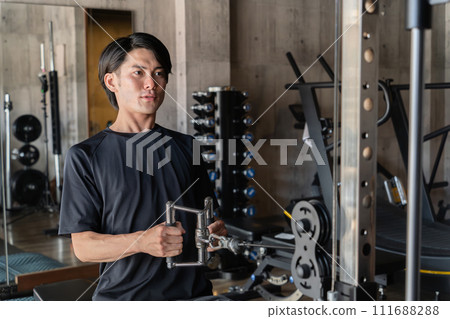 Young Asian man doing muscle training and working out at the gym/sports gym (back training/rowing) Young Asian man doing muscle training and working out at the gym/sports gym (back training/rowing) 111688288