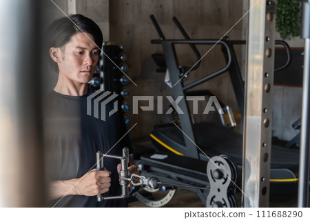 Young Asian man doing muscle training and working out at the gym/sports gym (back training/rowing) Young Asian man doing muscle training and working out at the gym/sports gym (back training/rowing) 111688290