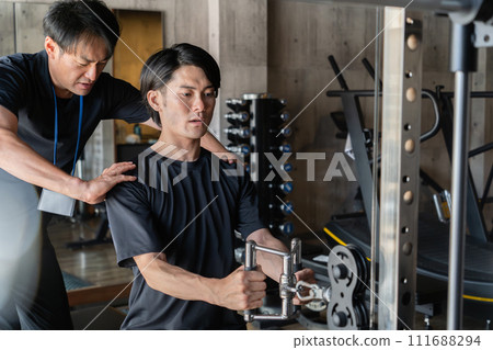 Young Asian man receiving form check at gym/personal gym (one-on-one/guidance/lesson) 111688294