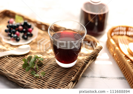 將葡萄汁倒入藤盤上的玻璃杯中 111688894