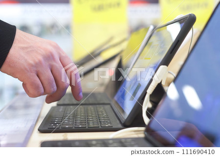 Buyer checking laptops in a computer store 111690410