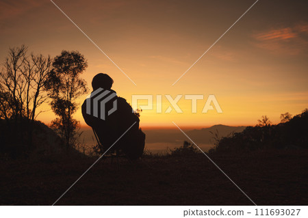 landscape and travel concept with solo freelancer man sit on chair and see sunrise with layer of mountain background landscape and travel concept with solo freelancer man sit on chair and see sunrise with layer of mountain background 111693027