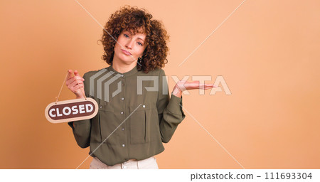 woman with closed sign on beige background 111693304